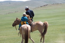 Mongolei: Vater und Sohn reiten aus